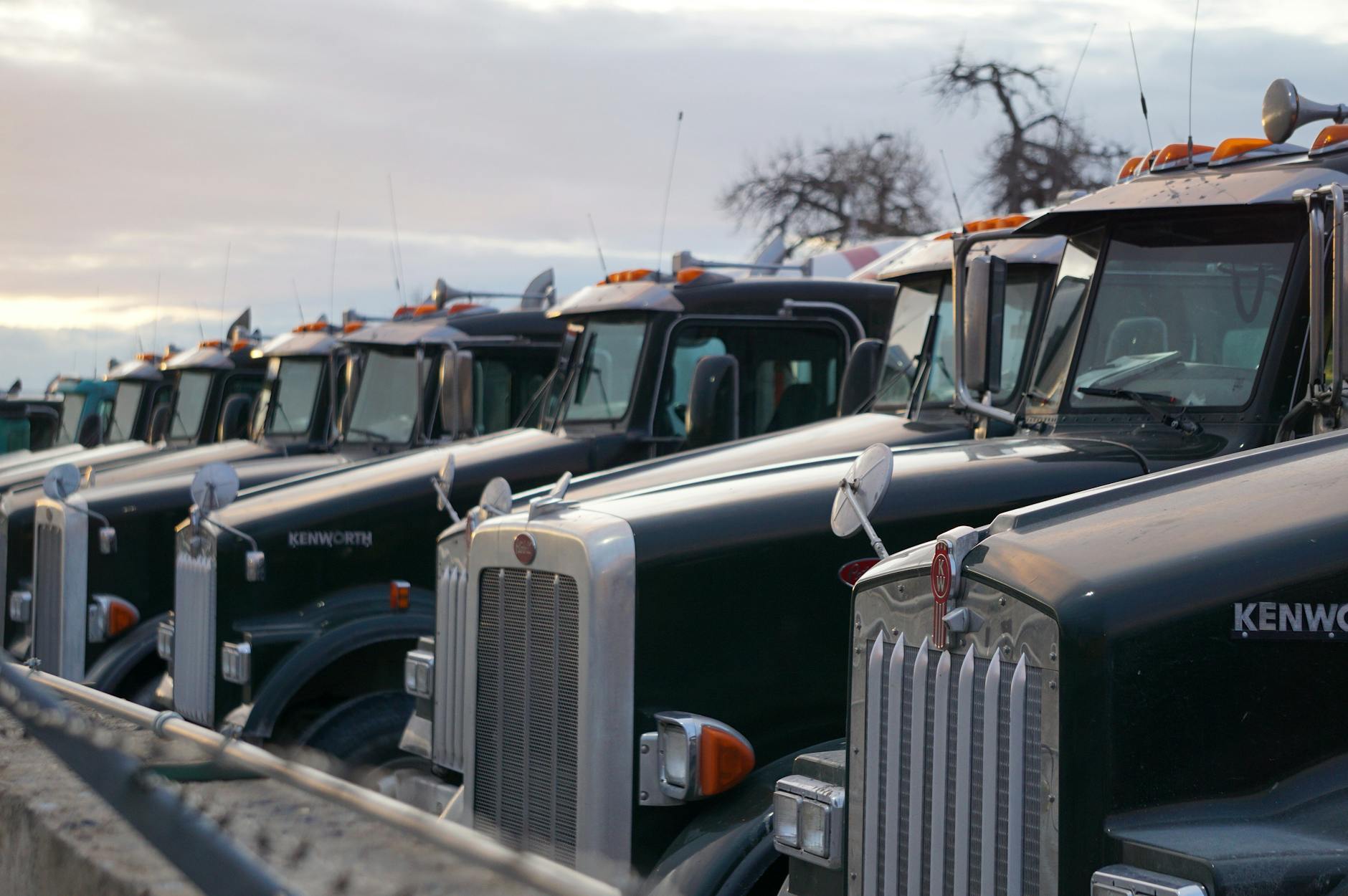 Szereg klasycznych ciężarówek Kenworth na parkingu floty firmowej