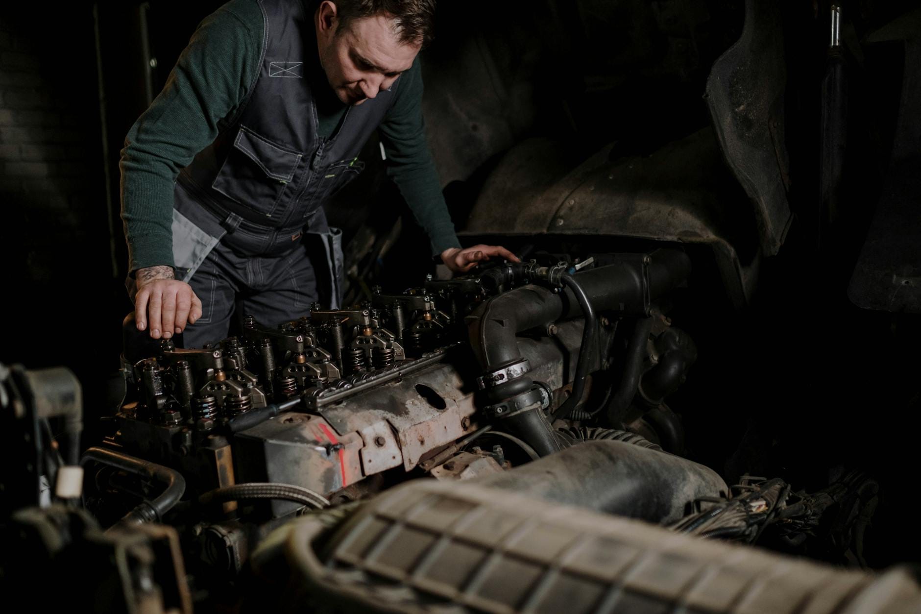 Mechanik naprawiający silnik diesla w warsztacie samochodowym