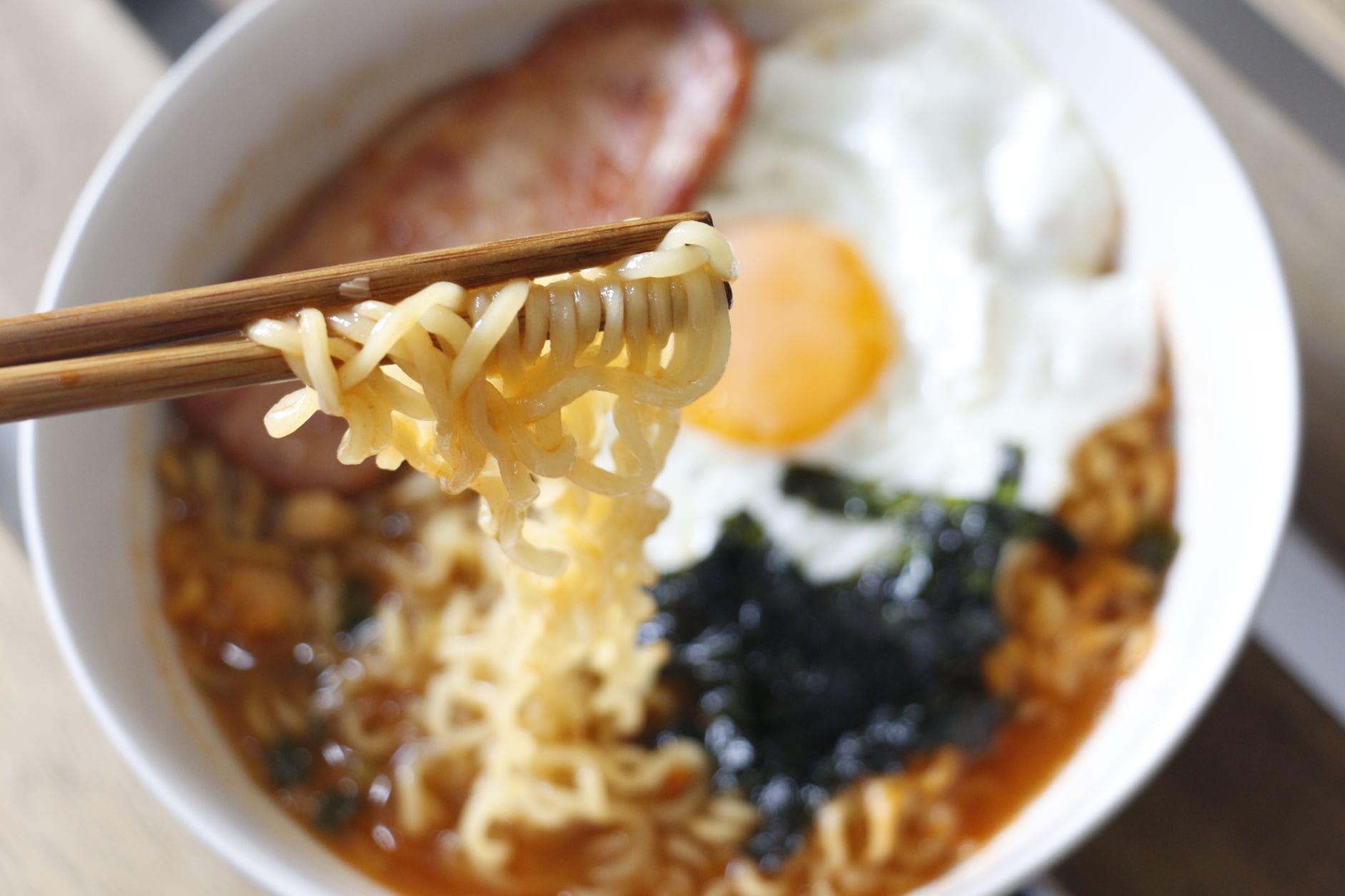 Zbliżenie na miskę ramen z jajkiem, boczkiem i wodorostami